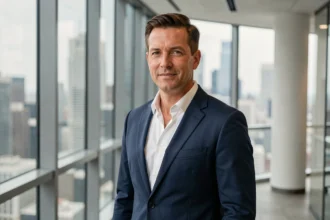 Homme d'affaires élégant en costume marine dans un bureau moderne avec vue sur la ville, portrait professionnel