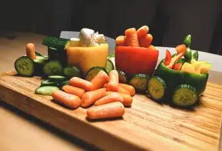 sliced carrots and green bell pepper on brown wooden chopping board