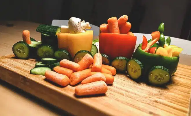 sliced carrots and green bell pepper on brown wooden chopping board